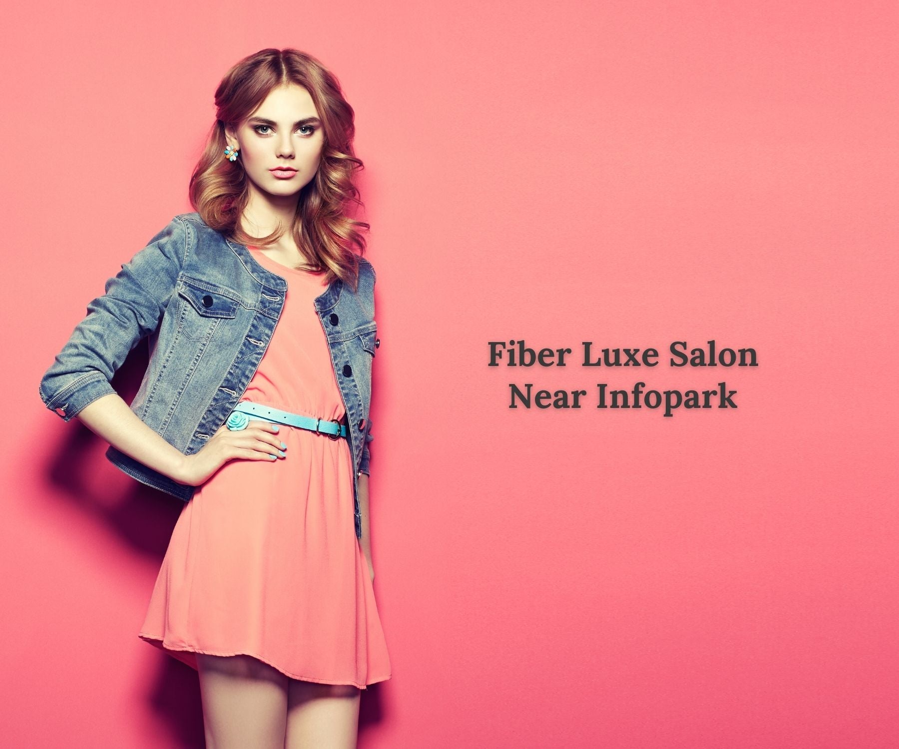 Woman in a pink dress and denim jacket against a pink background with 'Fiber Luxe Salon Near Infopark' text.